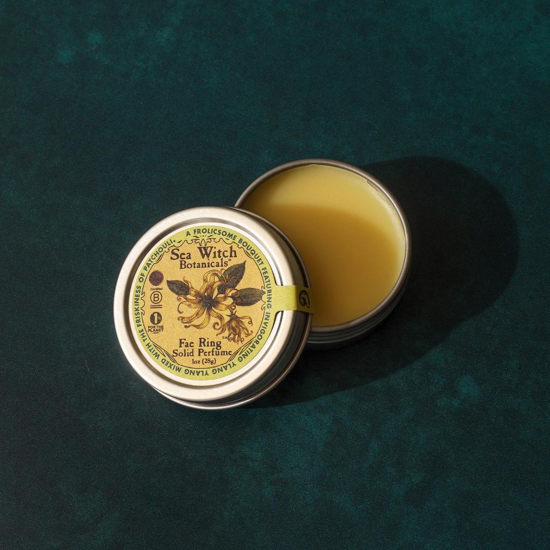 Open tin of Sea Witch Botanicals balm on a textured green background