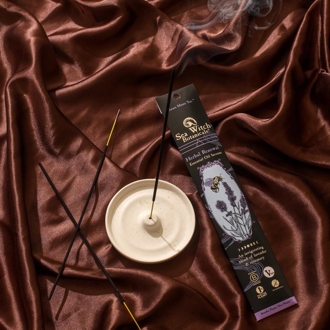 Incense sticks with a holder and packaging on a brown fabric background