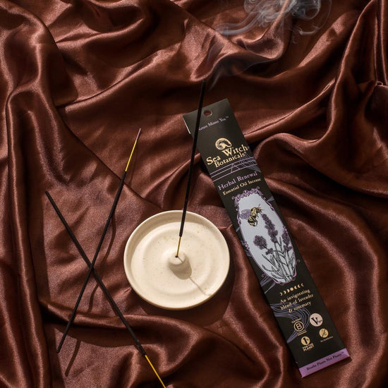 Incense sticks with a holder and packaging on a brown fabric background