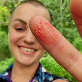 Model with Coral lip and cheek tint on her fingertip